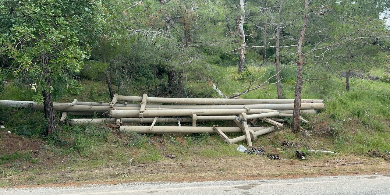 Yalancıboğaz yolunda yıkılan direkler orman kenarında unutuldu